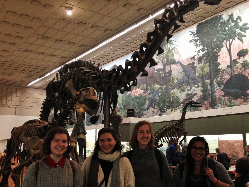 A group of ARCP 267 classmates posing in front of reconstructed dinosaur skeletons at Yale's Peabody Museum of Natural History.